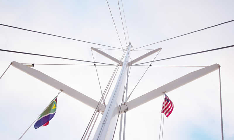 Segelboot mit gesetzter Gastlandflagge an der Steuerbord-Saling